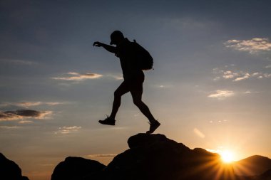 Siluet dağda günbatımında hiking bir gezgin. Özgürlük, risk, meydan okuma, başarı kavramı.