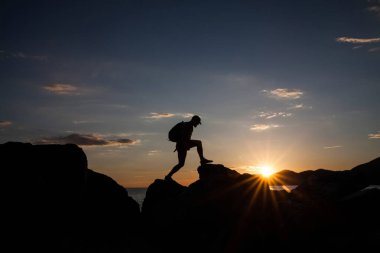 Siluet dağda günbatımında hiking bir gezgin. Özgürlük, risk, meydan okuma, başarı kavramı.