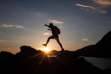 Siluet dağda günbatımında hiking bir gezgin. Özgürlük, risk, meydan okuma, başarı kavramı.