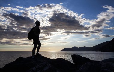 Dağda günbatımında hiking bir kadın gezgin silüeti. Özgürlük, risk, meydan okuma, başarı kavramı.