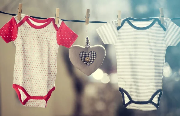Babykläder Och Ett Brunt Hjärta Hängande Klädstreck — Stockfoto