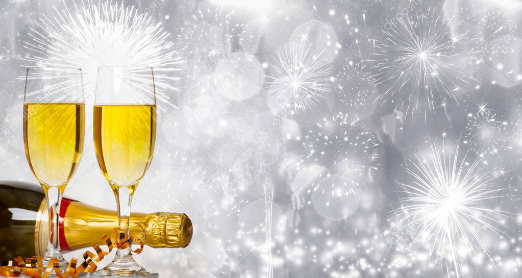Glasses of champagne on sparkling holiday background with fireworks