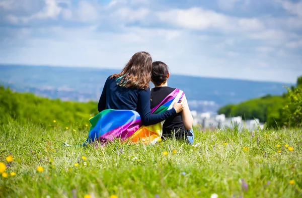 Lesbian lovers with LGBT flag. — Stock Photo, Image