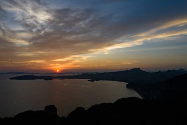 Tayland'da gün batımında kayalar ve okyanus.