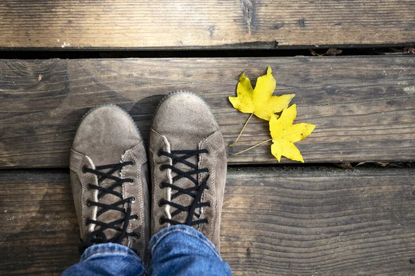 Imagem conceitual de pernas em botas e folhas de outono . — Fotografia de Stock