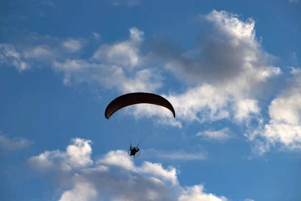 Silhueta de parapente sobre o céu azul . — Fotografia de Stock