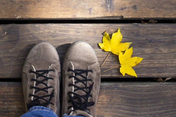 Koncepcyjny obraz nóg w butach i jesiennych liściach. — Zdjęcie stockowe