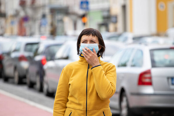 COVID-19 Pandemic Coronavirus. Woman in city street wearing face mask protective for spreading of disease virus SARS-CoV-2. Woman with protective mask on face against coronavirus disease.