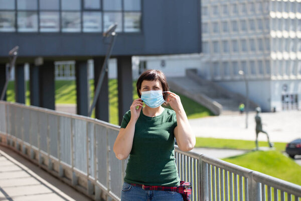 COVID-19 Pandemic Coronavirus. Woman in front of modern building wearing face mask protective for spreading of disease virus SARS-CoV-2. Woman with protective mask on face against coronavirus disease.