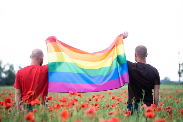 Gay Casal Segurando Gay Arco Íris Bandeira Sobre Bela Papoula — Fotografia de Stock