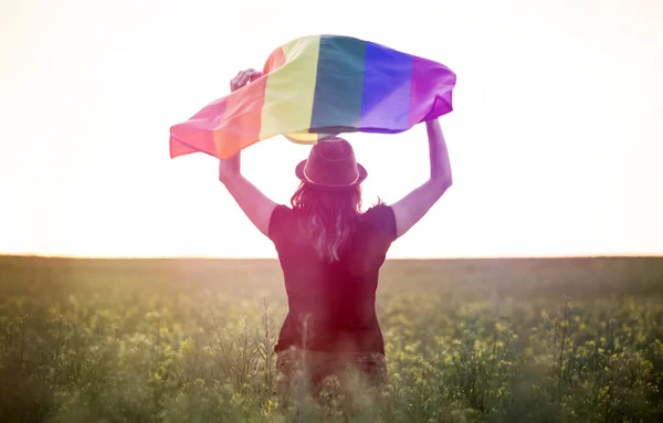 Γυναίκα Κρατώντας Μια Σημαία Gay Rainbow Πάνω Από Μπλε Καλοκαιρινό — Φωτογραφία Αρχείου