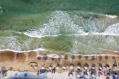 Renkli şemsiyeli kumlu sahil manzarası yazın şeffaf mavi suyla insanları deniz koyunda yüzdürüyor. Thassos Adası, Yunanistan 'da Seyahat.
