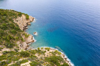 Yunanistan 'da dalgaların, kayaların ve saydam denizin havadan görünüşü. Turkuaz su ve uçurumlarla dolu soyut yaz arkaplanı. Seyahat kavramı.