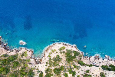 Yunanistan 'da dalgaların, kayaların ve saydam denizin havadan görünüşü. Turkuaz su ve uçurumlarla dolu soyut yaz arkaplanı. Seyahat kavramı.