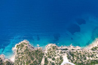 Yunanistan 'da dalgaların, kayaların ve saydam denizin havadan görünüşü. Turkuaz su ve uçurumlarla dolu soyut yaz arkaplanı. Seyahat kavramı.