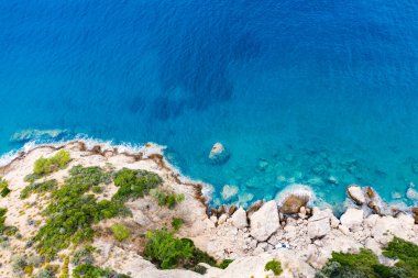 Yunanistan 'da dalgaların, kayaların ve saydam denizin havadan görünüşü. Turkuaz su ve uçurumlarla dolu soyut yaz arkaplanı. Seyahat kavramı.