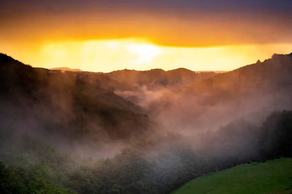 夏日群山中迷人的梦幻般的落日 鸟瞰着下面雾蒙蒙的山谷 — 图库照片