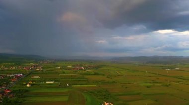 Transilvanya 'daki küçük bir köyün üzerinde gök gürültülü gökyüzünün 4k videosu.