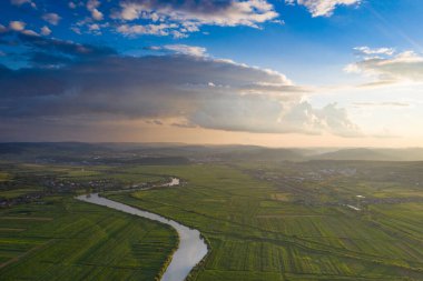 Romanya 'nın Transilvani kentinde nehrin kıvrımlı suları üzerine gün batımı, hava ve atmosfer manzarası. Romanya 'nın güzel kırsal-drone manzarası.