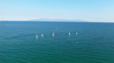 Açık denizde yelkenli bir teknenin üzerinde uçmak - havadan 4K video görüntüleri.