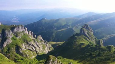Sis ve bulutlarla dolu güzel bir yaz gününde Romanya 'daki Ciucas Dağları üzerinde 4K hava manzarası