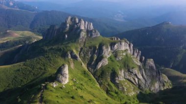 Sis ve bulutlarla dolu güzel bir yaz gününde Romanya 'daki Ciucas Dağları üzerinde 4K hava manzarası