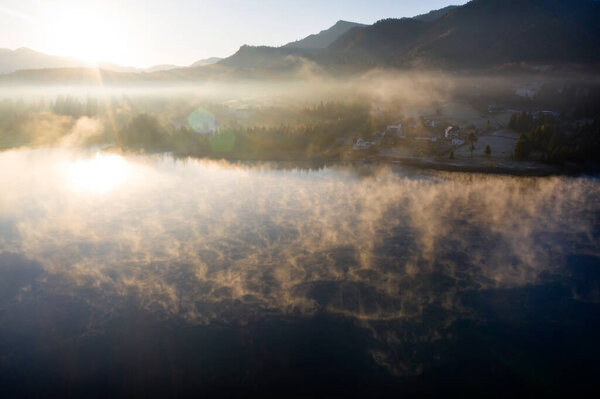 Magic foggy sunrise over Colibita lake at autumn, Romania.