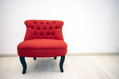 Minimalist iç odada tek kırmızı kadife koltuk