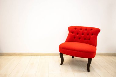 Minimalist iç odada tek kırmızı kadife koltuk