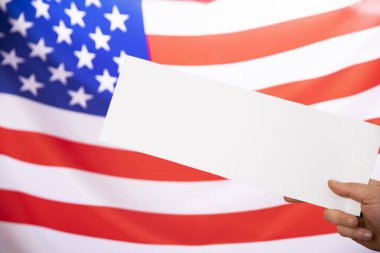 Arka planda ABD bayrağı bulunan beyaz panolarla el ele tutuşmak - ABD seçim kavramı.