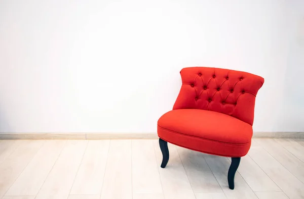 Single red velvet armchair in minimalist interior room