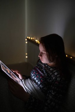 Akıllı telefon kullanan genç kız, gece geç saatte yatakta yatan tablet. Çocukların ekran bağımlılığı konsepti..