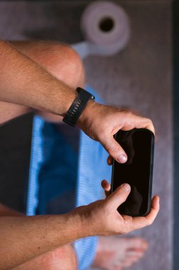 Tuvaletteki klozetin üzerinde akıllı telefonunu kullanan beyaz bir adam. Bağımlılık, sosyal ağa bağımlılık.