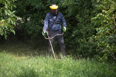 Çim biçme makinesiyle çimleri biçmek. Bahçe işleri konsepti.