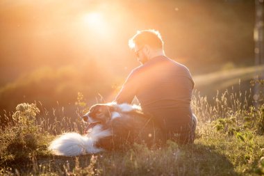 İnsan ve köpeği güzel gün batımının tadını çıkarıyorlar..