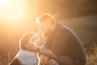 Köpeğine şefkat ve ilgi gösteren mutlu bir adam.