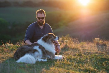 İnsan ve köpeği güzel gün batımının tadını çıkarıyorlar..