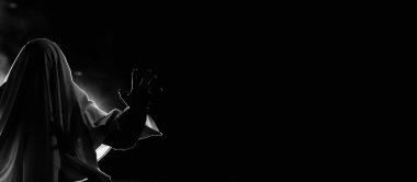 Dark banner with copy space for Halloween. Horror background of a ghostly figure on a dark Halloween night.
