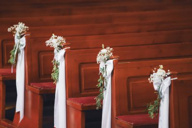 Beyaz çiçekli ve peçeli bir kilisenin içinde düğün süsü.