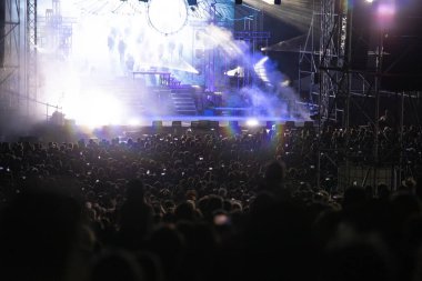 Konserde kalabalık - Parlak renkli sahne ışıkları önünde tezahürat yapan kalabalık