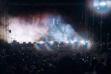 Konserde kalabalık - Parlak renkli sahne ışıkları önünde tezahürat yapan kalabalık