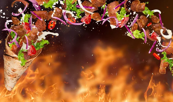 Turkish Kebab yufka with flying ingredients and flames. — Stock Photo, Image