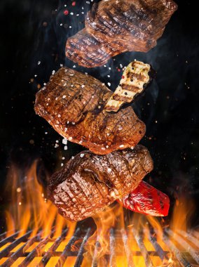 Lezzetli biftekler havada uçuşuyor demir ızgaralar ateş ateşiyle yanıyor.