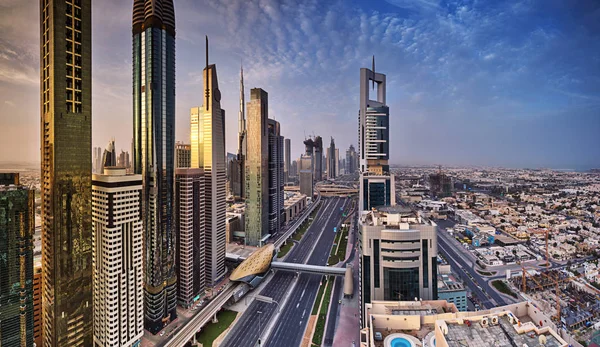 De skyline van Dubai tijdens zonsopgang, wegverkeer Sheikh Zayed, Verenigde Arabische Emiraten. — Stockfoto