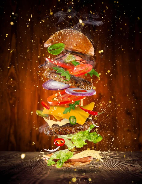 Stora läckra burger med flygande ingredienser. — Stockfoto