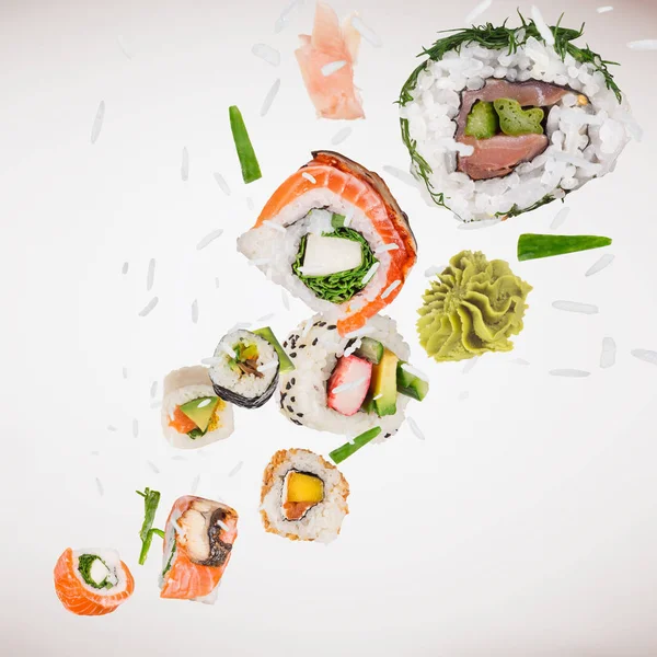 Kousky lahodného japonského sushi zamrzlé ve vzduchu. — Stock fotografie