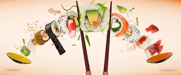 Pedaços de delicioso sushi japonês congelado no ar. — Fotografia de Stock