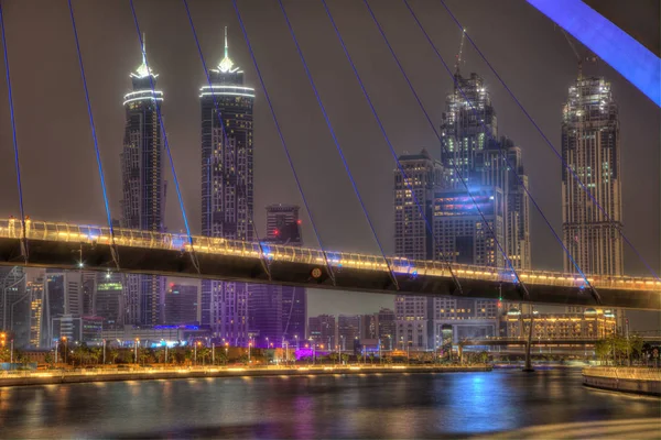 Dubai, Verenigde Arabische Emiraten - mei 2018: Kleurrijke zonsondergang over Downtown Dubai wolkenkrabbers en tolerantie brug van de Dubai water aquaduct. — Stockfoto