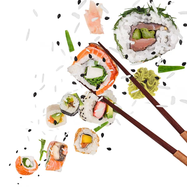 Pedaços de delicioso sushi japonês congelado no ar. — Fotografia de Stock