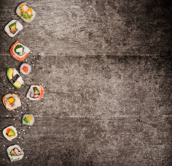 Tradycyjne japońskie sushi kawałki na rustykalne podłoże betonowe. — Zdjęcie stockowe